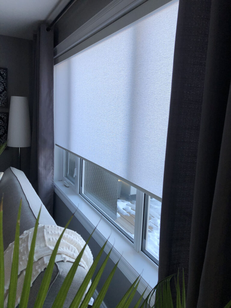 Motorized Roller Shade Partially Lowered Behind Drapes