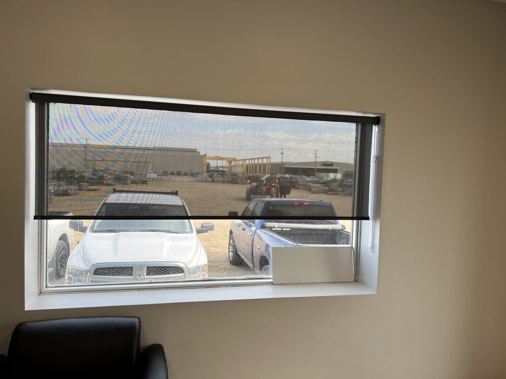 Office Window with Solar Shade Overlooking Industrial Lot