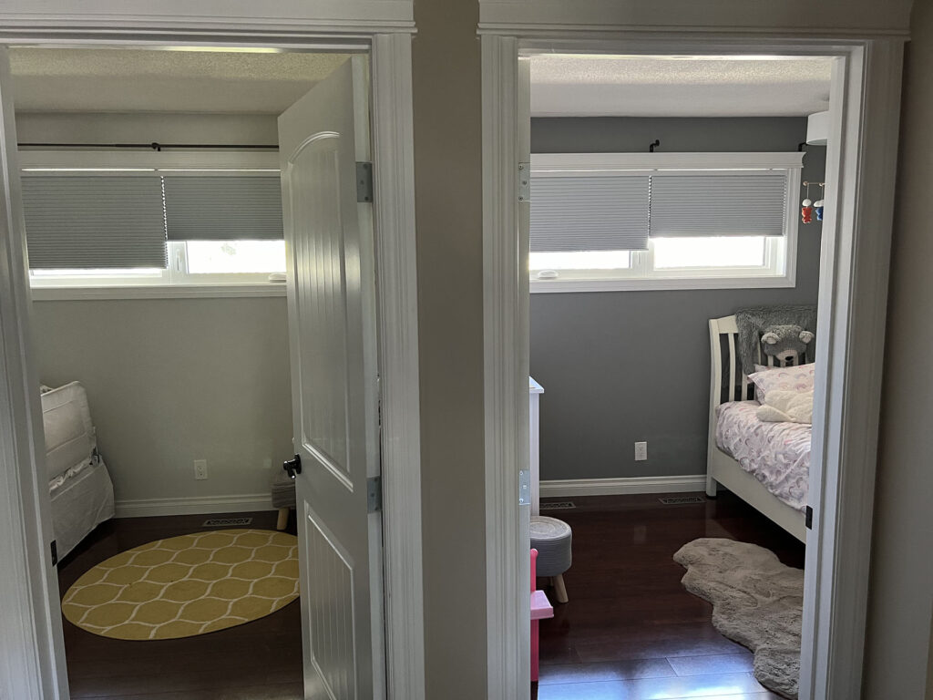 View Through Open Doors into Two Bedrooms with Window Blinds